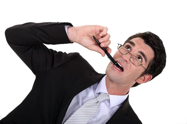 Бизнесмен жует свою ручку — стоковое фото