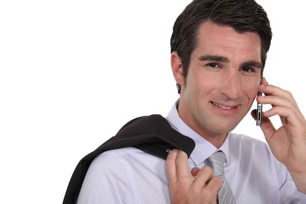 Бизнесмен стоял с курткой через плечо во время звонка — стоковое фото
