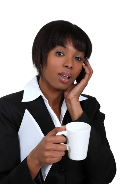 Businesswoman with mug of coffee and telephone — Stock Photo, Image