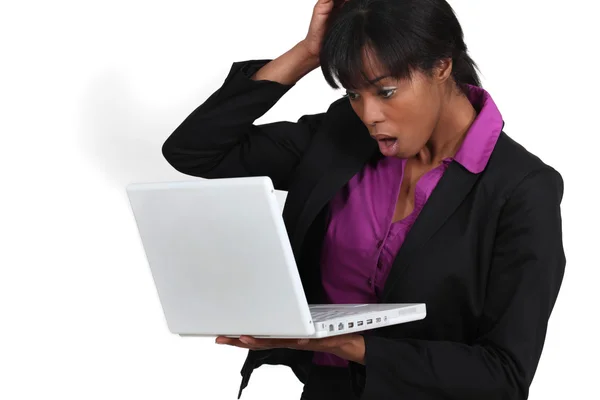 Mulher olhando em choque para seu laptop — Fotografia de Stock