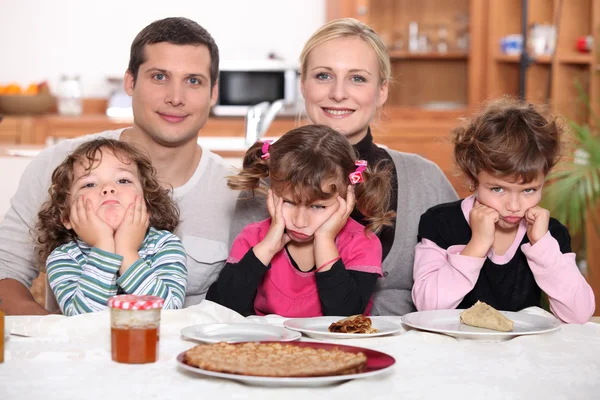 Sulky children with pancakes — Stock Photo, Image