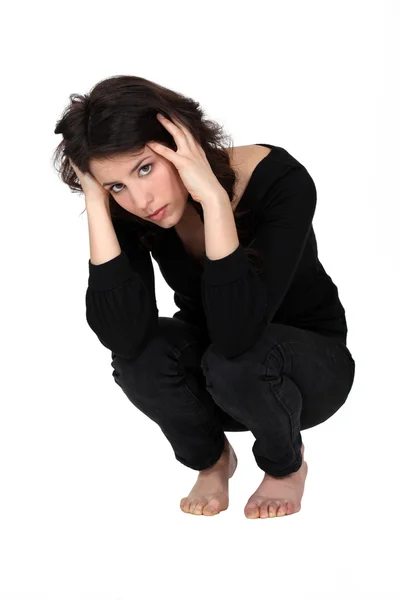 A depressed woman squatting Royalty Free Stock Images