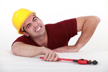 Workman with a wrench in a tight spot clipart