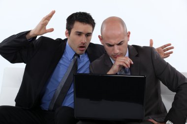 Two stressed office worker with laptop clipart