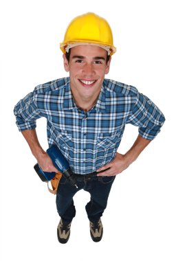 Young tradesman holding a power tool clipart