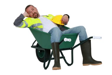 Lazy worker slumped in wheelbarrow clipart
