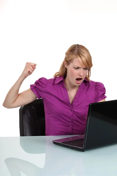 Молодая женщина сердится на свой ноутбук — стоковое фото
