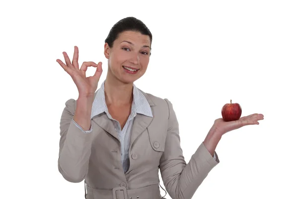 Donna che tiene una mela e dà il segno OK — Foto Stock