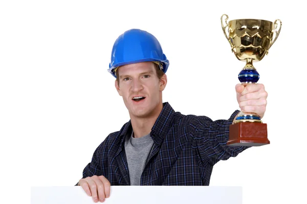 Řemeslník drží zlatý pohár — Stock fotografie