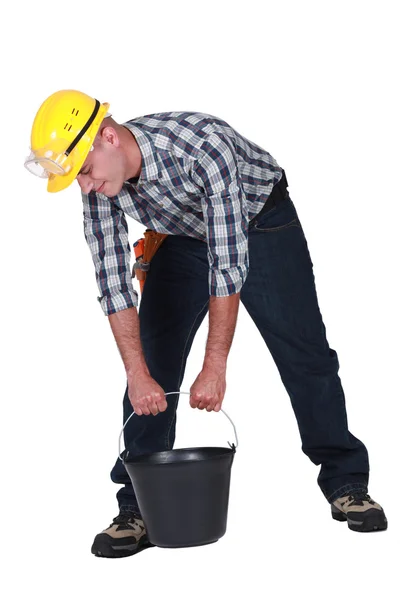 Trabalhador manual tentando levantar balde — Fotografia de Stock