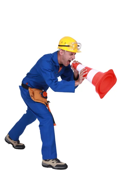 Trabalhador da construção gritando em um cone de tráfego — Fotografia de Stock