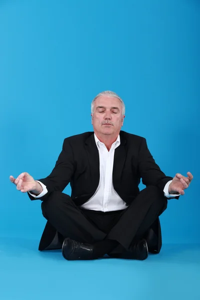 Empresário sentado em uma posição de lótus — Fotografia de Stock