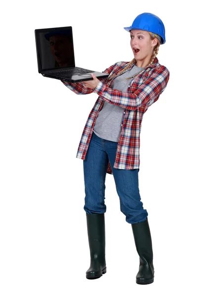Construtor feminino surpreendido pelo laptop — Fotografia de Stock