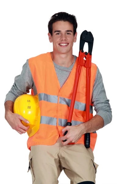 Trabalhador em um colete reflexivo com capacete e cortadores de parafusos — Fotografia de Stock