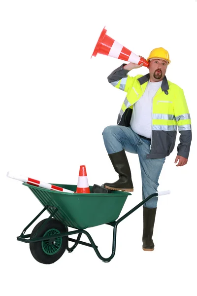 Trabalhador ouvindo através de um cone de tráfego — Fotografia de Stock