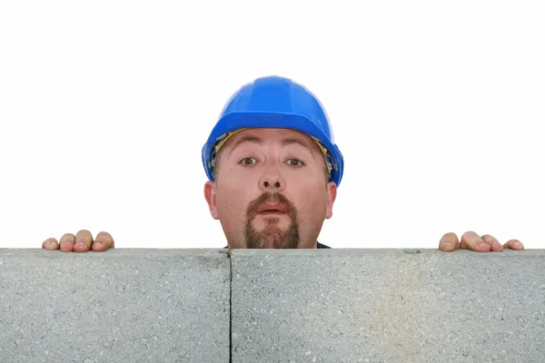 Bauarbeiter blickt über Mauer — Stockfoto