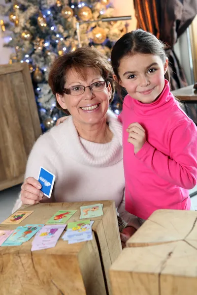Großmutter und Enkelin spielen zu Weihnachten ein Kartenspiel — Stockfoto