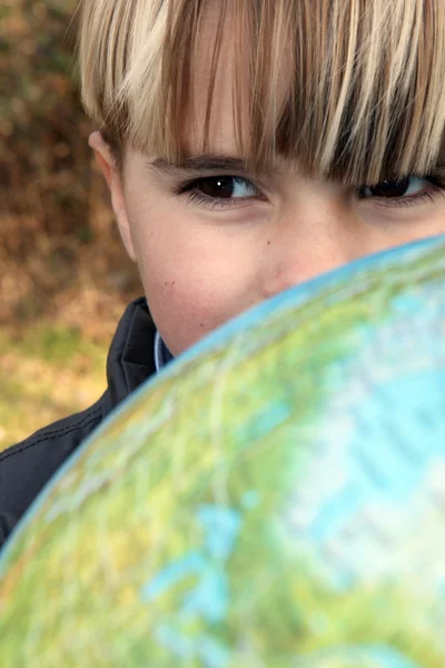 Little boy stood outdoors with globe — Stock Photo, Image