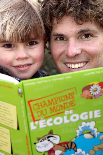 Padre e hijo leyendo libro sobre ecología —  Fotos de Stock