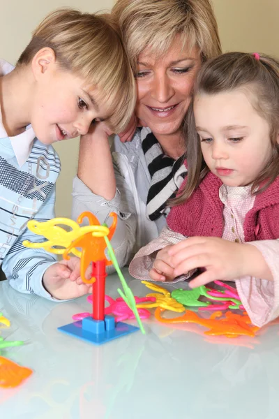 Mère et enfants jouant à un jeu — Photo