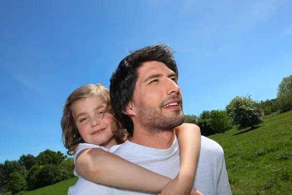 Uomo dando figlia a cavalluccio — Foto Stock