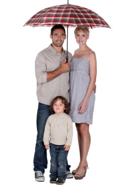 Family stood under umbrella clipart