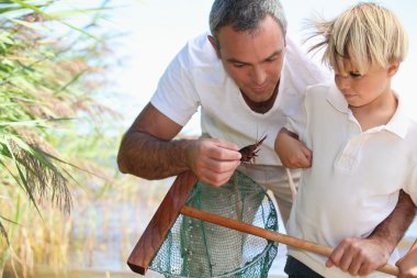 Father and son fishing with net clipart