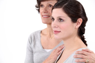 Mother putting her hands on her daughter's shoulders clipart