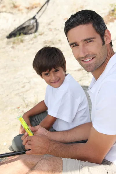 Father and son sitting on the floor — Stock Photo, Image