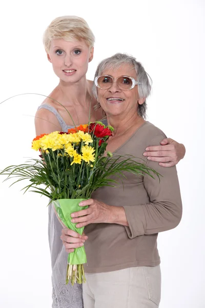 Sondotter och mormor med blommor — Stockfoto