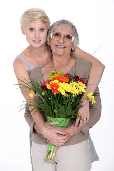 Ofreciendo flores madre hija — Stok fotoğraf