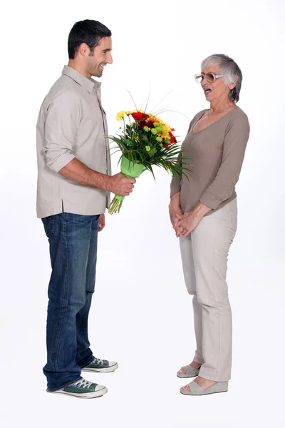 Son giving mother flowers — Stock Photo, Image