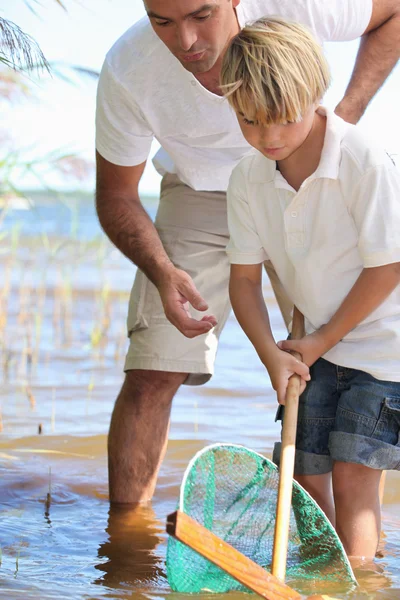Ojciec uczy syna do ryb z netto — Zdjęcie stockowe
