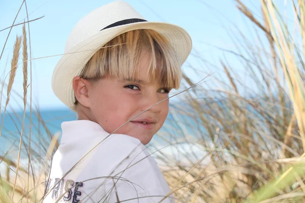 Ragazzo biondo circondato da canne — Foto Stock