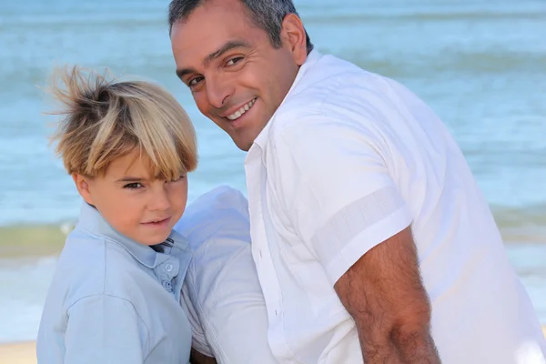 Far och son på stranden — Stockfoto