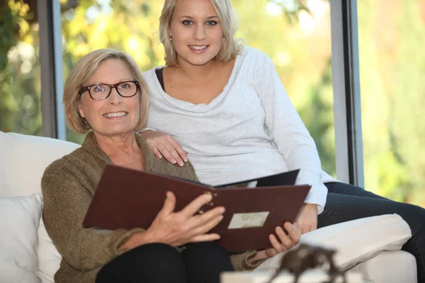 Grootmoeder en kleindochter kijken naar foto 's — Stockfoto