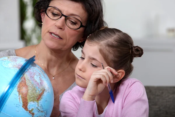 Mutter und Tochter blicken auf Globus — Stockfoto