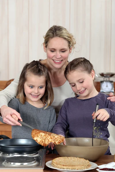 Mãe e filhas cozinhar panquecas — Fotografia de Stock