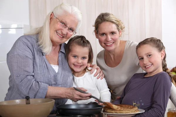 Mãe, avó e meninas cozinhar panquecas — Fotografia de Stock