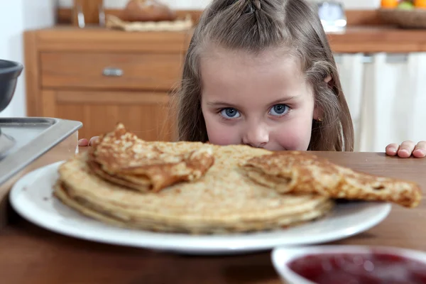 Greedy girl looking at pancakes — Zdjęcie stockowe