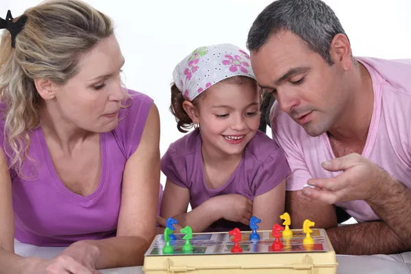En familj som spelar ett spel tillsammans — Stockfoto