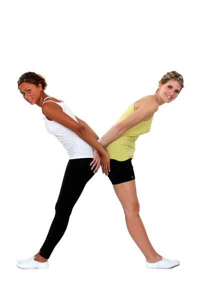 Две женщины в спортивной одежде, формирующие букву X — стоковое фото