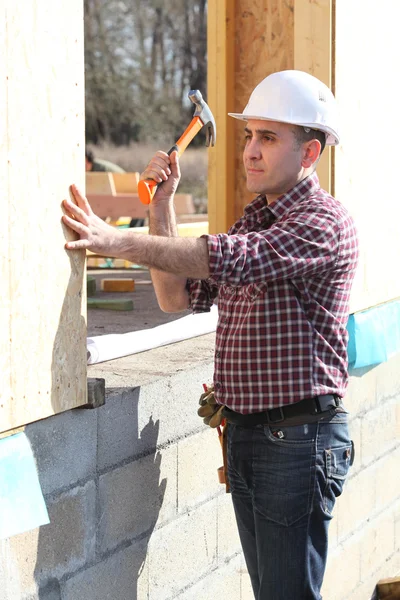 Builder arbetar på ett hus — Stockfoto