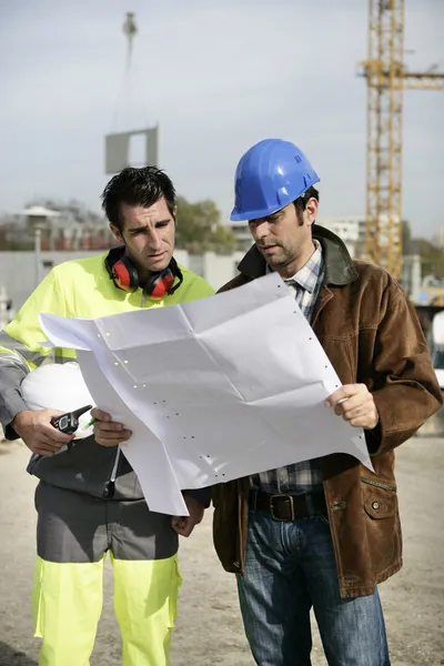 Supervisores de estaleiros de construção a olhar para um plano — Fotografia de Stock
