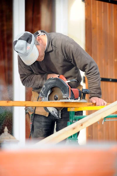 Homem usando serra circular no canteiro de obras — Fotografia de Stock