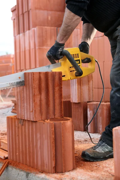 Builder cutting bricks to size — Stock Photo, Image