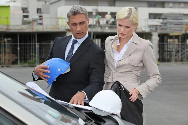 Férfi és női építészek állt autóval — Stock Fotó
