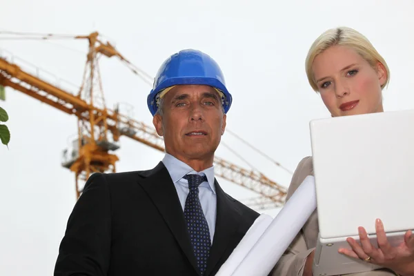 Vrouwelijke architect met foreman in bouwplaats — Stockfoto