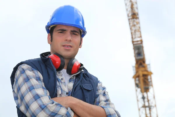 Byggnadsarbetare som står framför en kran — Stockfoto