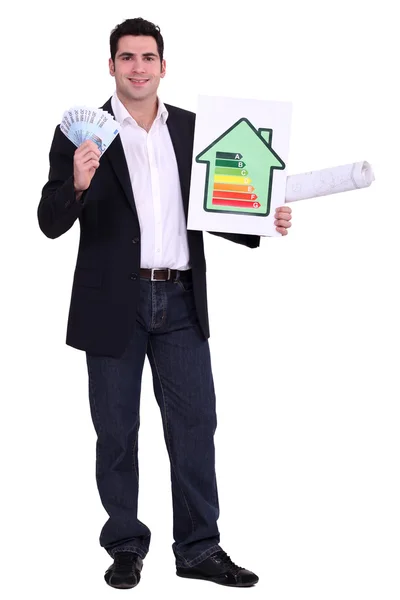 Engenheiro segurando dinheiro e um sinal de classificação de eficiência energética — Fotografia de Stock